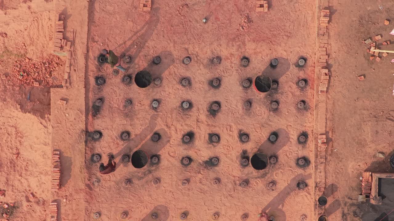 Vista aerea di una fabbrica di mattoni industriale con fumo e operai in Bangladesh
