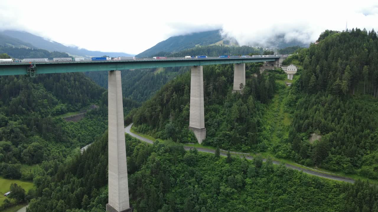 Real-time drone footage showing vehicles traveling and pausing on the iconic Brenner Bridge in Tyrol, a vital Alpine crossing on the Austria–Italy route