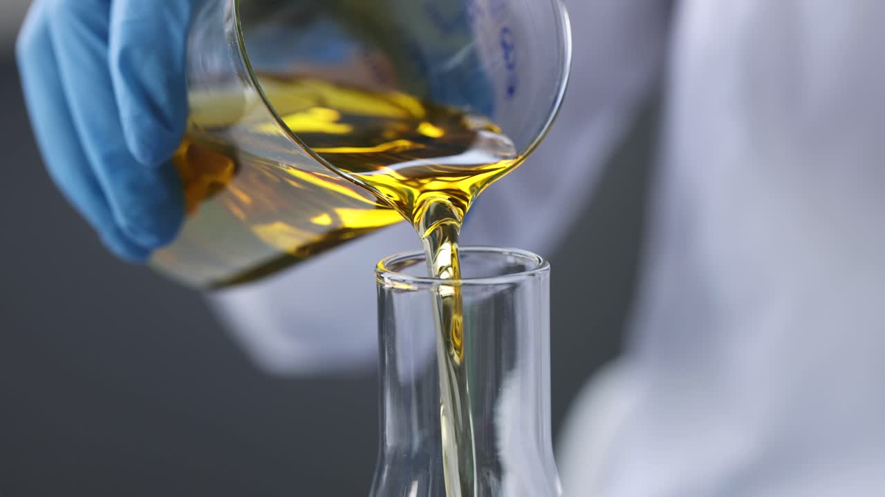 Scientist chemist pouring motor oil into test tube closeup 4k movie