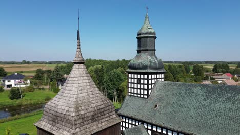 historyczny pół drewniany kościół i dzwonnica dach powietrzne krążące niebieskie niebo