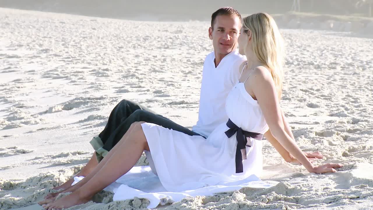 남자 와 여자 가 낮 에 해변 에서 휴식 을 하고 있다