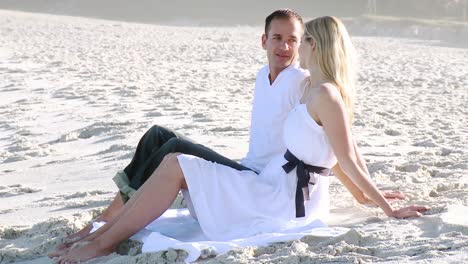hombre y mujer relajándose en la playa durante el día