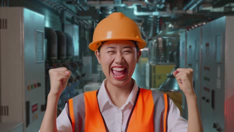 happy female engineer celebrating success in industrial setting