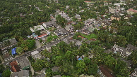 Unawatuna-Sri-Lanka-Aerial-v14-establishing-shot,-birds-eye-view-drone-flyover-hillside-coastal-town-along-A2-Galle-road,-tilt-up-reveals-hilly-landscape---Shot-with-Mavic-3-Cine---April-2023