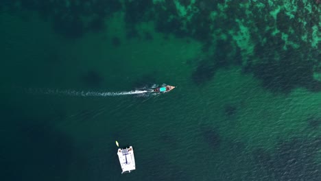 An-Einem-Tropischen-Inselstrand-Vertäutes-Longtail-Boot-Mit-Touristen,-Die-Auf-Dem-Weißen-Sand-Spazieren