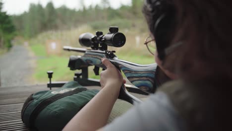 Practice-and-patience-as-young-woman-fires-at-distant-target,-handheld