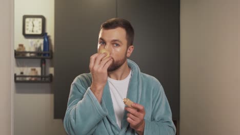 retrato de un hombre guapo y bien arreglado que se aplica crema base en la cara con una esponja