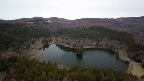 aerial of bass lake near blowing rock north carolina with moses cone estate atop the hilltop in the background