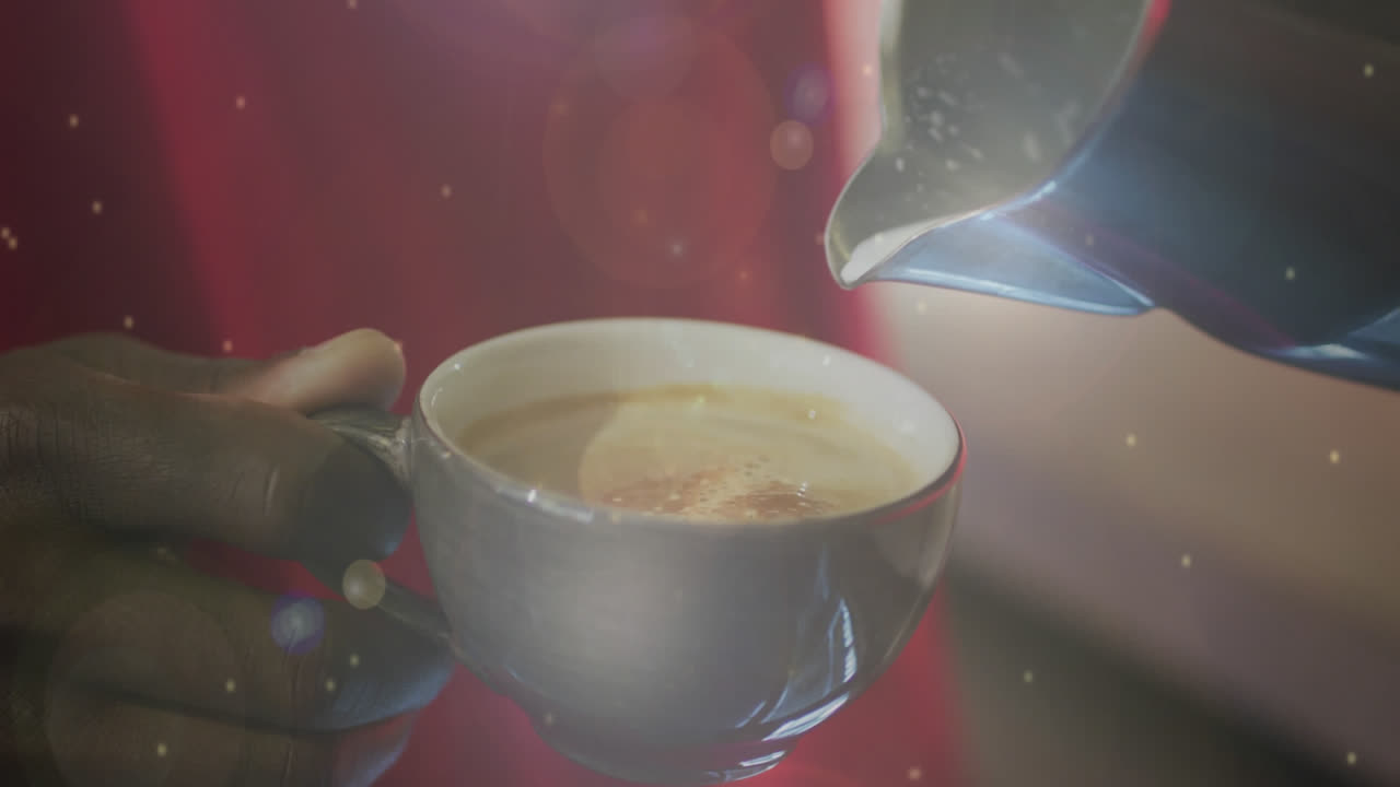 커피 컵에 우유를 부는 사람의 손으로 떠다니는 입자의 애니메이션