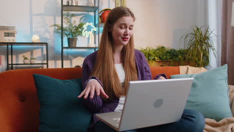 Woman-sitting-on-home-couch,-looking-at-camera,-making-video-conference-call-with-friends-or-family