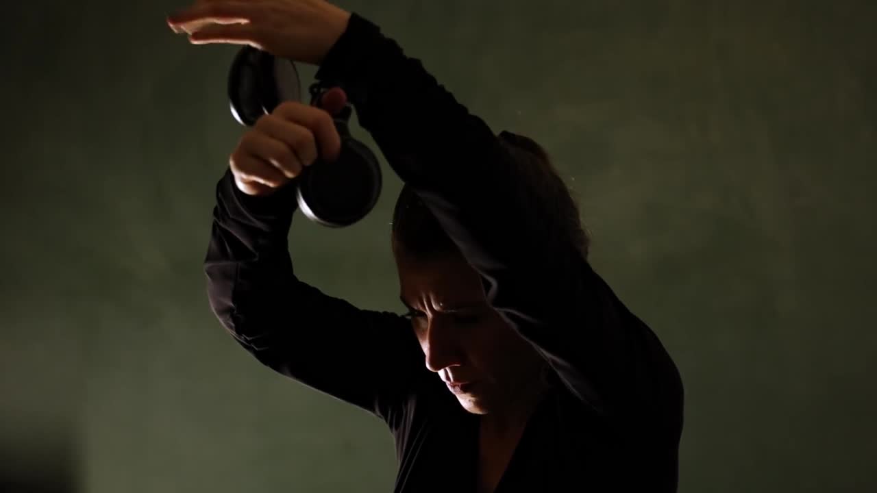 Primo piano di una ballerina di flamenco con nacchere sul palco. Ripresa a mano.