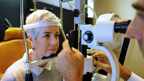 optometrista examinando los ojos del paciente con una lámpara de hendidura 4k