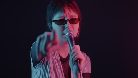 woman singing into a microphone with neon lighting
