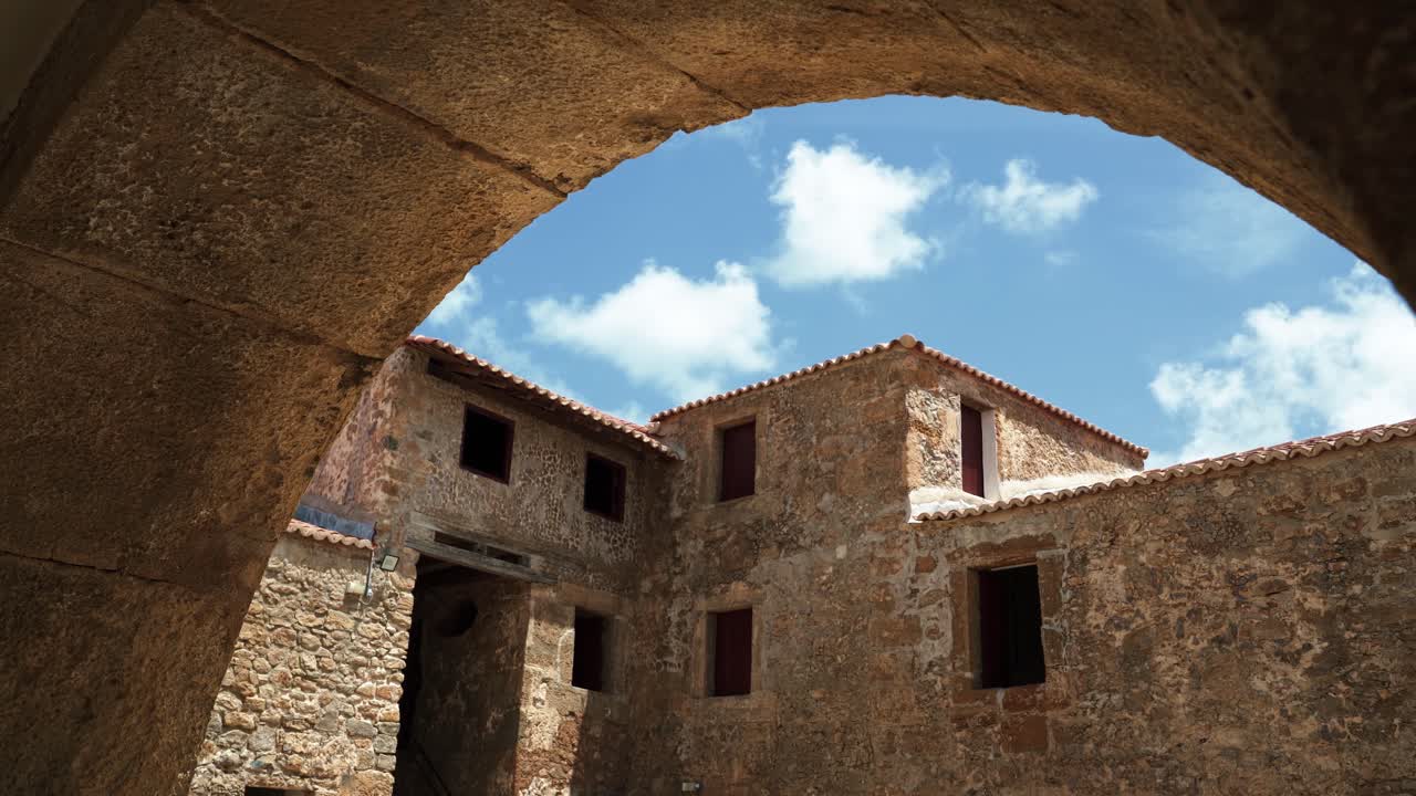 Old historic Portuguese inspired stone buildings from under an archway inside of the famous tourist attraction Natal Reis Magos military fort in Rio Grande do Norte, Brazil on a warm summer day