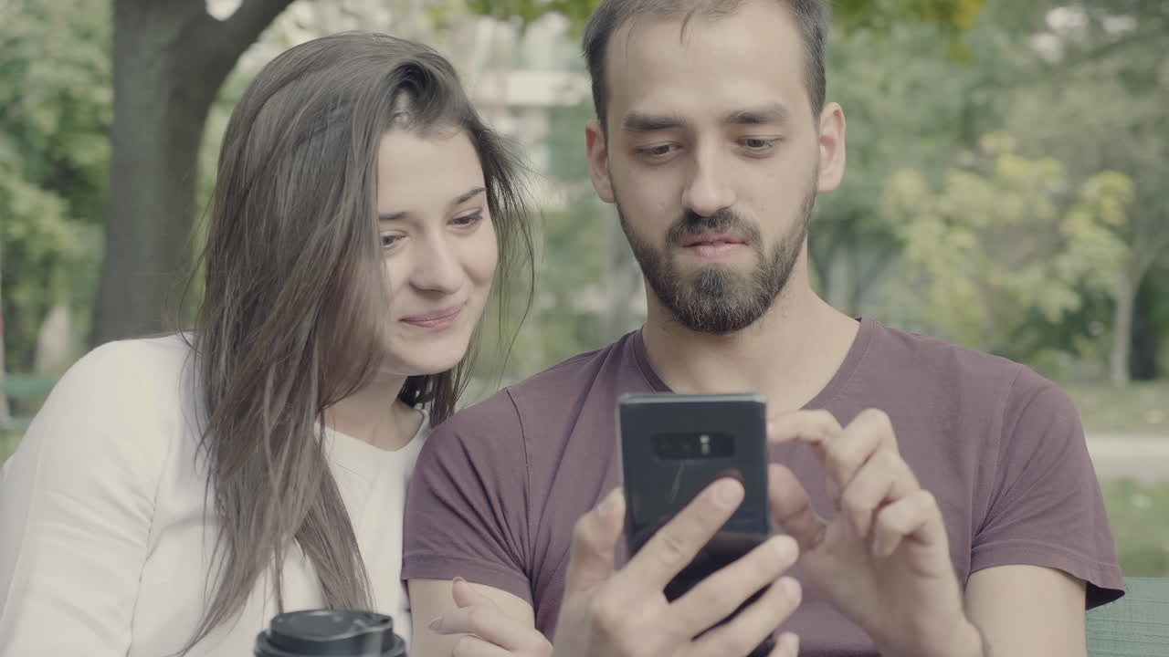 Couple looking at phone in park