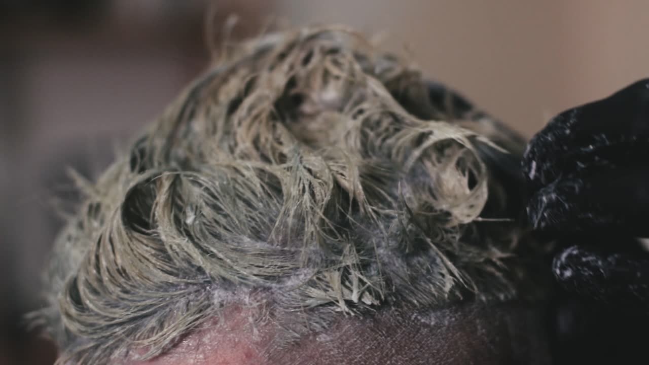 고객의 머리를 손가락으로 마사지하여 염색하는 미용사