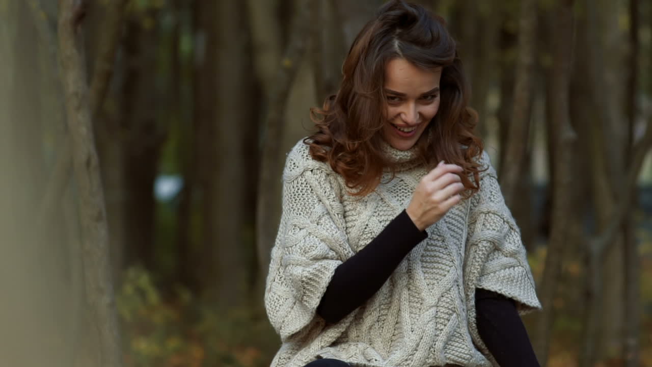 Fashion woman walking in autumn park. Outdoor fashion video of young beautiful lady surrounded autumn leaves
