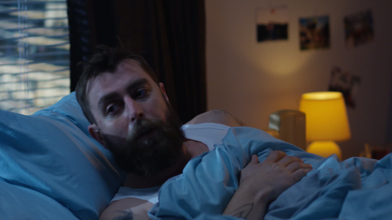 Man in Bed Experiencing Discomfort at Night