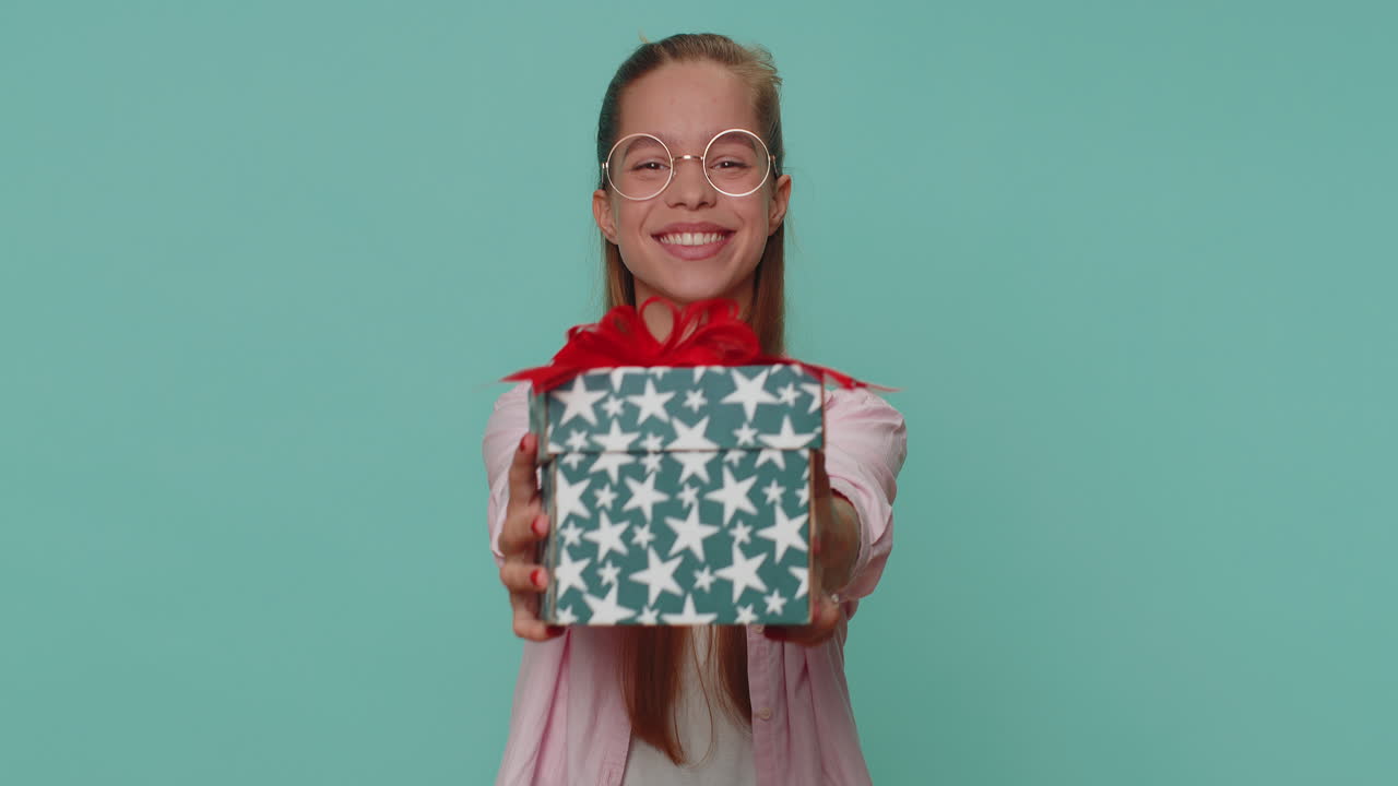 Bella ragazza che presenta una scatola regalo di compleanno, offre un regalo incartato, bonus carriera, festa di celebrazione