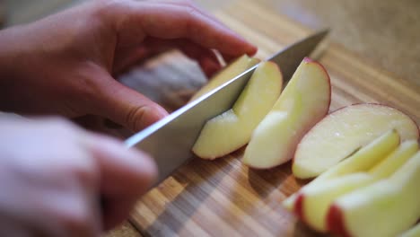 Toma-En-Cámara-Lenta-De-Alguien-Que-Usa-Un-Cuchillo-Para-Cortar-Una-Manzana-Madura-En-Rodajas-Pequeñas