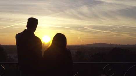 Couple-silhouette-looking-at-the-landscape.-Sunrise-light