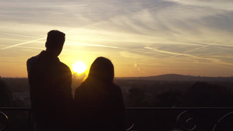 couple silhouette looking at the landscape. sunrise light