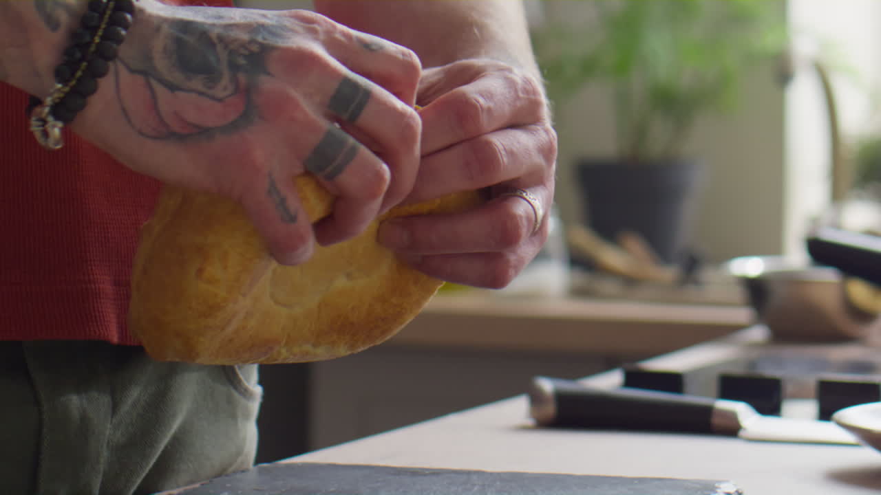 Chef Tearing Bread into Halves
