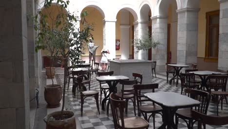 Reveal-shot-of-girl-in-dress-and-summer-outfit-walking-through-beautiful-hall-inside-Syros-Town-hall-and-looking-around