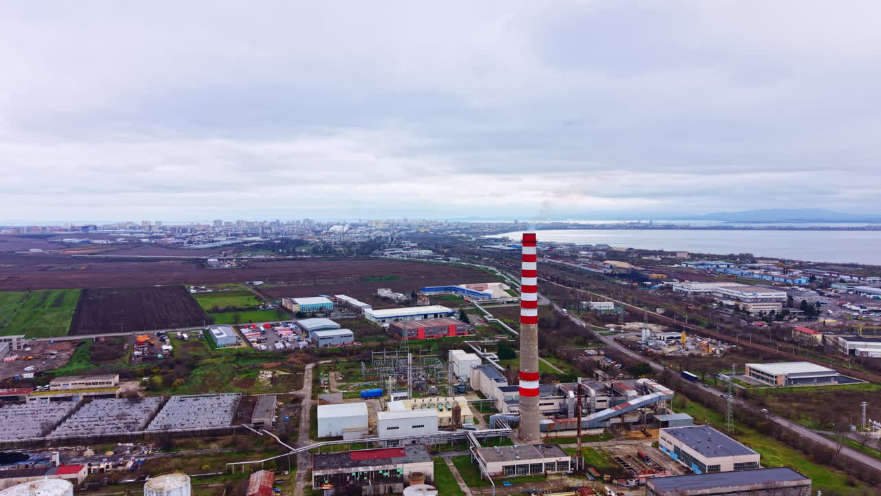 Industri- og landskapsutsikt nær byen på en overskyet dag med fabrikker og et kraftverk