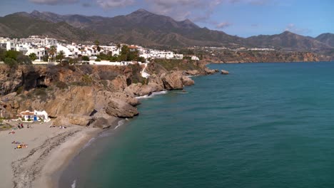 Inclínate-Desde-La-Playa-Con-Gente-Hacia-Los-Acantilados-Con-Casas