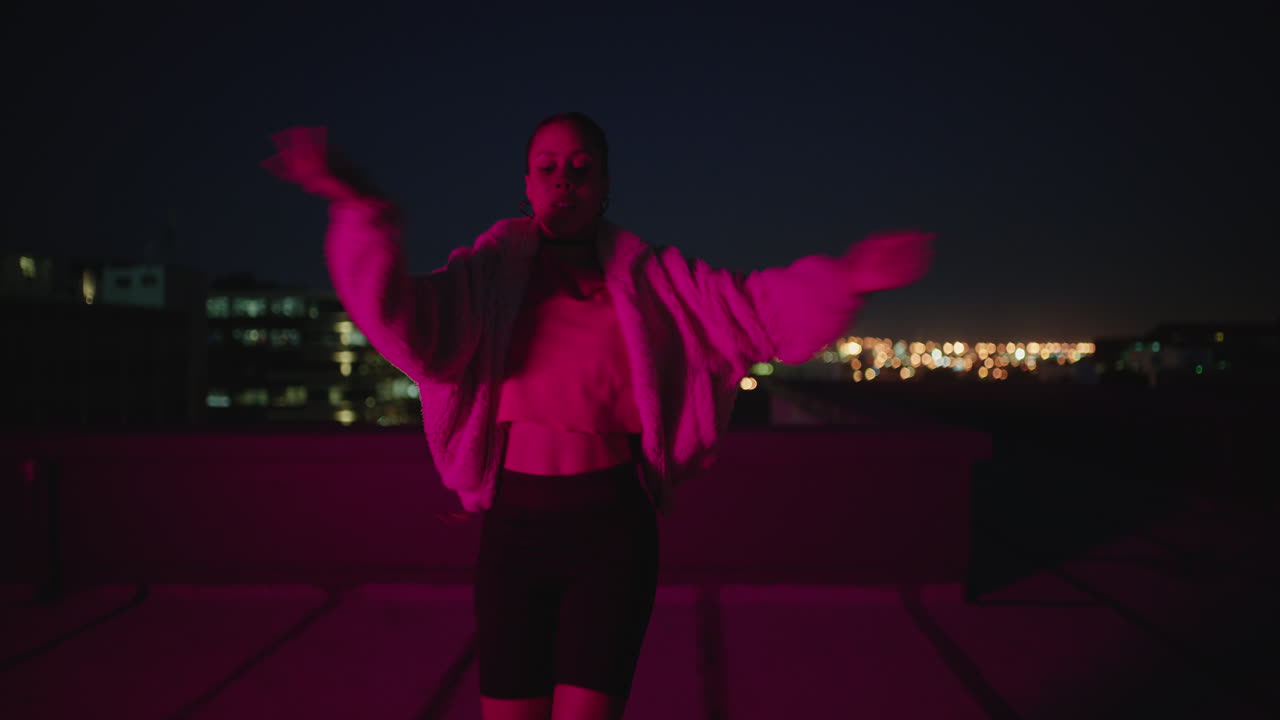 happy woman dancing on roof top girl performing hip hop dance style having fun freestyle dancer in urban city at night with red light