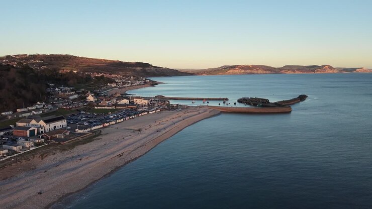 Ripresa aerea di Lyme Regis, Dorset, Regno Unito, che mostra la spiaggia, il porto e il famoso Cobb