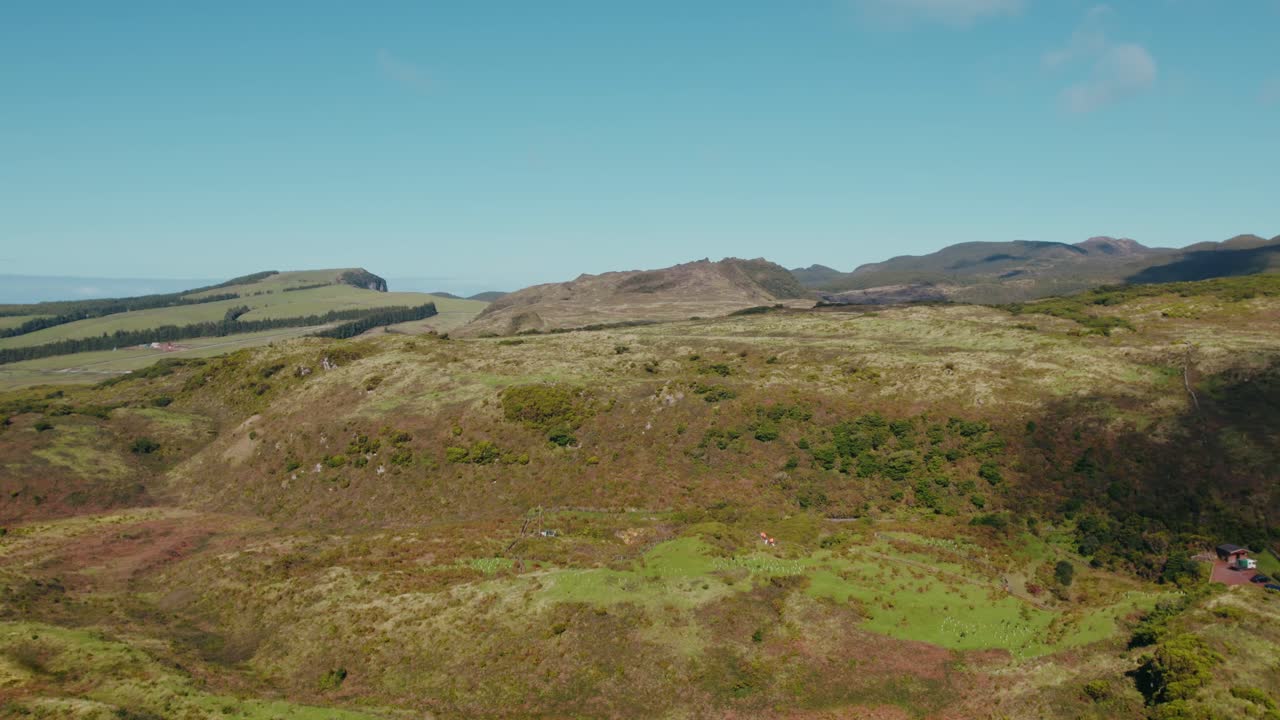 Aerial view over Serra da Estrela reveals rugged mountains and patchwork valleys spreading across Portugal's wild interior, bathed in light beneath a clear sky