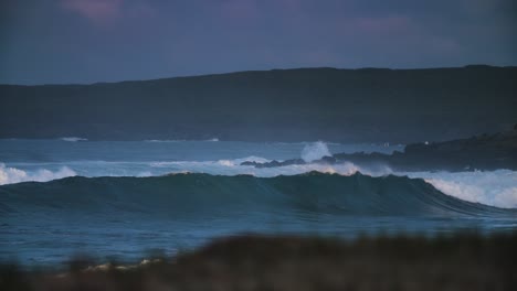 Waves-crash-against-a-rocky-shore-in-golden-light-1