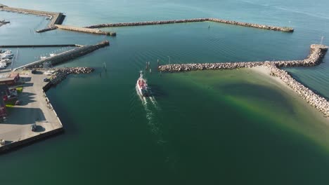 Ein-Fischerboot-Bewegt-Sich-In-Dieser-Luftaufnahme-Eines-Kleinen-Fischerhafens-An-Einem-Sonnigen-Frühlingsabend-Entlang-Des-Äquators-Des-Hafens