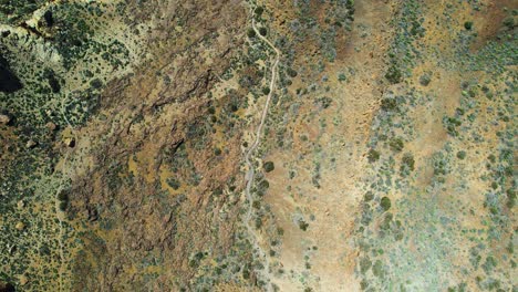 top down view over a desert landscape with curvy road