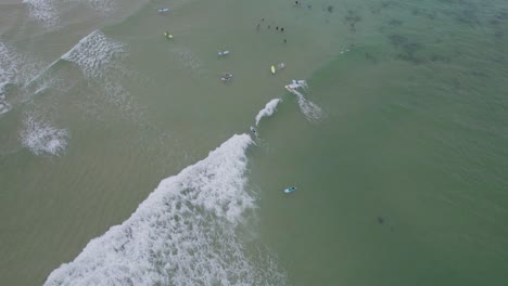 waves splashing on surfers in the sea in hastings point, tweed shire, nsw, australia