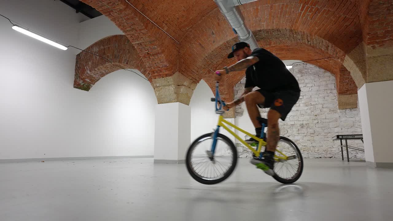 Ciclista che guida la sua bici all'interno di una casa facendo acrobazie - ripresa fluida.