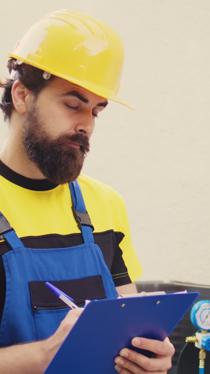Técnico de vídeo vertical inspeccionando los niveles de freón