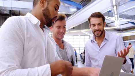 Business-executives-discussing-over-laptop