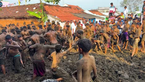 villagers celebrate the unique gumatapura cow dung festival in karnataka during diwali, playfully engaging in a traditional mud and cow dung fight. cultural event symbolizing community unity and joy.