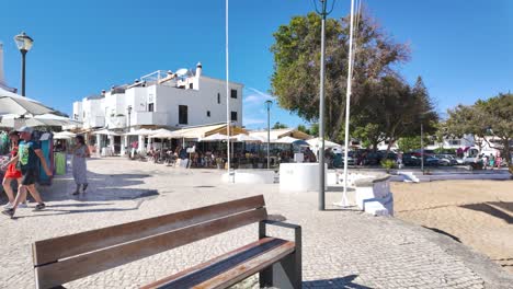 lively coastal town square with market stalls and outdoor cafes