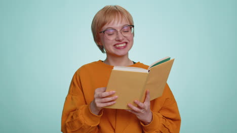 Young-woman-in-glasses-reading-funny-interesting-fairytale-story-book,-laughing,-leisure-hobby