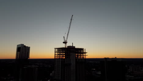 Grúa-Silueta-Encima-De-La-Construcción-De-Rascacielos-Al-Atardecer