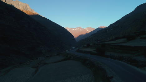 una foto aérea de una carretera de montaña desierta y curva