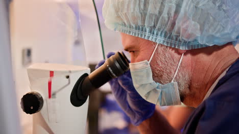 scientist looking through a microscope in a laboratory setting.