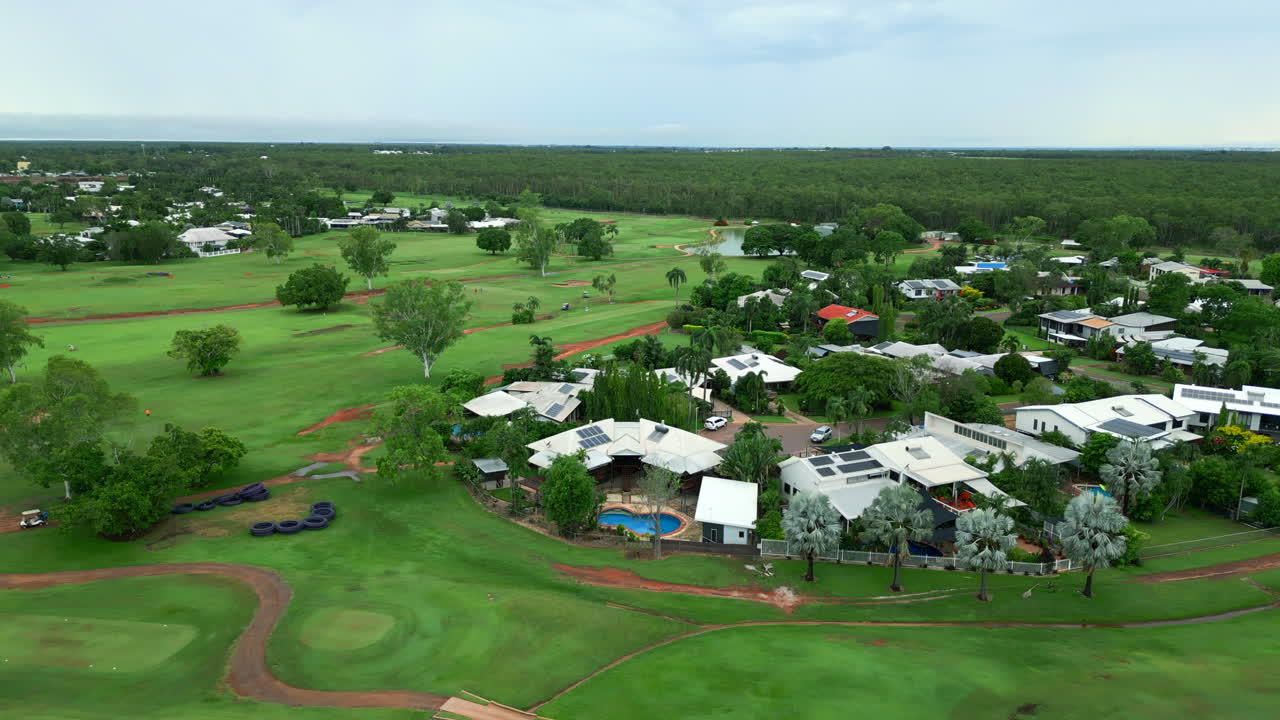 호주 마라라 다윈 (marrara darwin) 에서 수영장과 태양 전지 패널이 있는 골프장 주택의 공중 드론