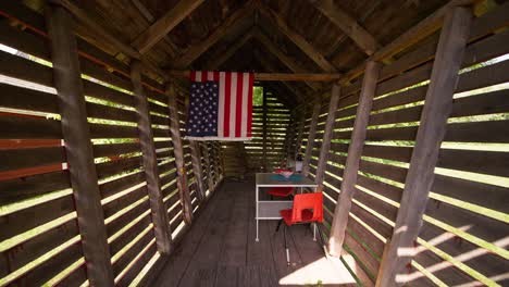 push in wide shot of an outdoor kids playroom with a table and chairs and an american flag hanging