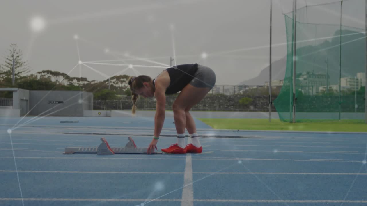 Sprinter adjusting blocks on blue track, preparing for sprint while particle overlay tracing motion