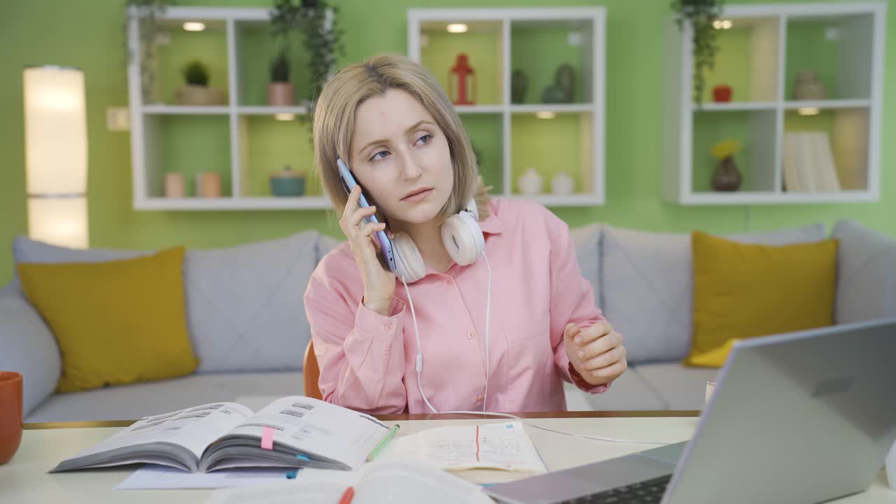 una estudiante universitaria enojada hablando por teléfono.